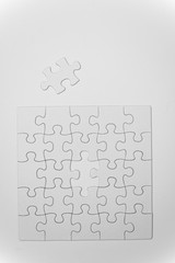 white, empty puzzles with a missing piece on a white background