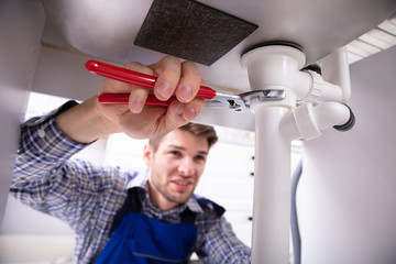 Plumber Repairing Sink Pipe