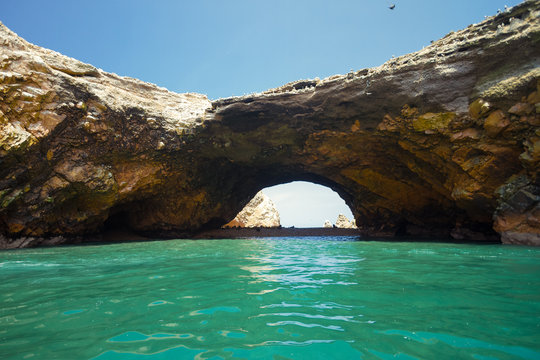 Cave of the Ballestas Islands (Paracas, Peru) with sea lions and birds on the rocks