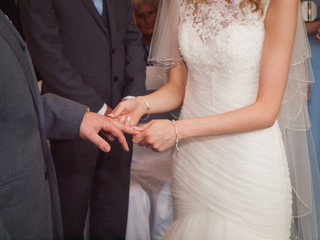 Wedding rings. Wedding day. Hands of bride and groom in solemn process of exchanging rings, symbolizing the creation of new happy family.
