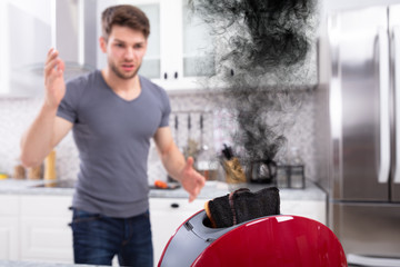 Man Looking At Burnt Toasts In Toaster