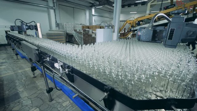 Glass bottle are getting stacked together and slowly relocated