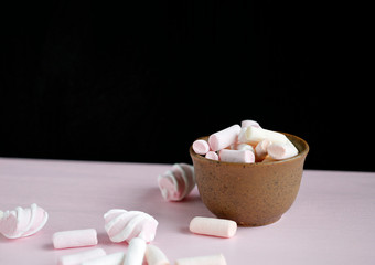 Fototapeta na wymiar pink and white marshmallows in a mug with coffee on a wooden background