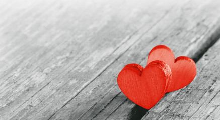 Fototapeta premium Two red hearts on old wood