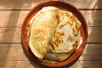Traditional fried pancakes on a plate, top view