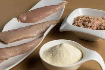 Sports bodybuilding supplement. White porcelain scoop with whey protein vanilla flavor powder, raw chicken breasts and tuna in oil