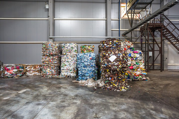 Plastic bales of rubbish at the waste treatment processing plant. Recycling separatee and storage of garbage for further disposal, trash sorting. Business for sorting and processing of waste.