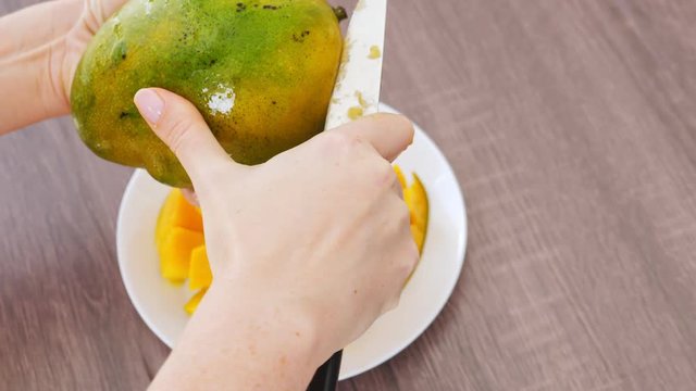 Cutting ripe mango on cubes slices , closeup