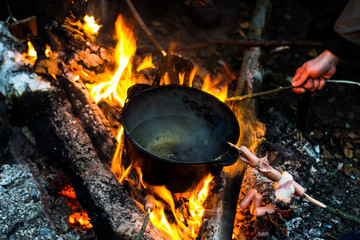 Roast sausages over a fire in nature.