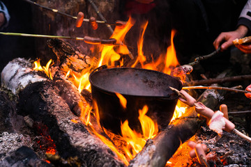 Roast sausages over a fire in nature.