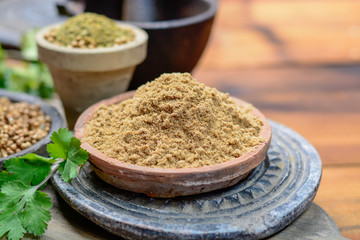 Clay bowls wirh dried coriander seeds and coriander powder close up, spices collection