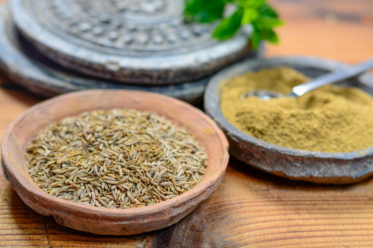Old clay bowls wirh cumin seeds and cumin powder close up, spices collection