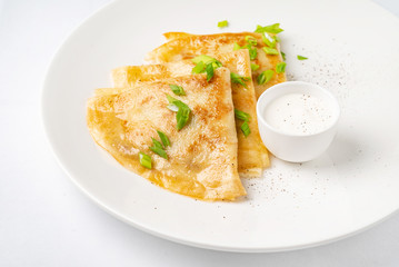 Crepes Suzette sour cream on white plate over white background, copy space. Delicious homemade Crepes for breakfast. - Image