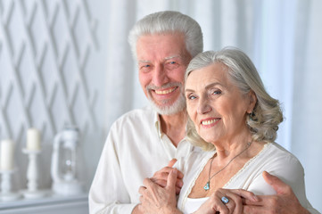 Portrait of cute senior couple posing at home