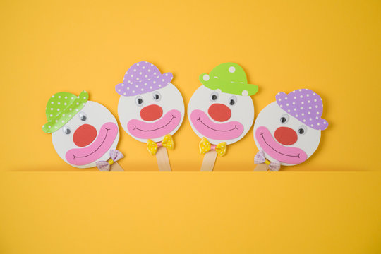 Jewish holiday Purim background with childish paper clowns.