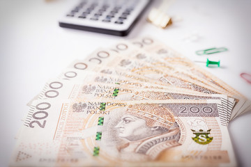 Calculator and money on white background, polish currency, polish zloty, banknotes