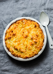 Chicken, bacon and leek cottage pie on a grey background,top view