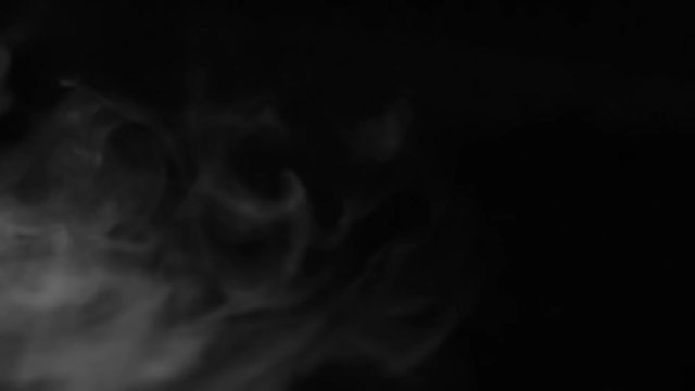 Light Scraps of Fog in Motion. Scraps of ghostly white mist slowly floating on a black background. Motion at a rate of 240 fps