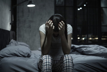 Young woman covering face with hands, staying up at night, feeling helpless and crying