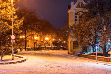 The road rises up in the night city, all covered with snow