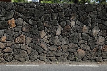 Stone fence separating the roadway and building © kazanovskyiphoto