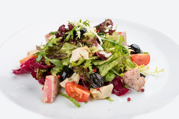 Salad with fried tuna and artichokes. On white background