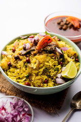 Aloo/Kanda Poha or Tarri Pohe with spicy chana masala/curry. selective focus