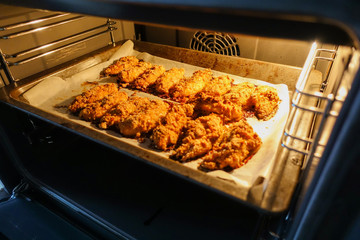 Freshly baked chicken fillet on a baking sheet in an electric oven. Cooking chicken nuggets. Series.