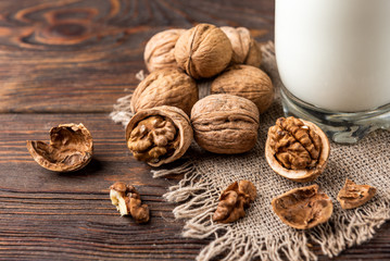 Walnut milk on wooden background.