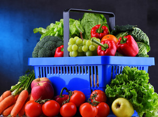 Fresh organic fruits and vegetables in plastic shopping basket