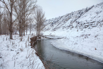 winter scenery with river and snowy hills