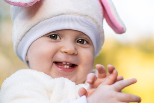 Baby girl with chubby cheeks smiling and laughing.