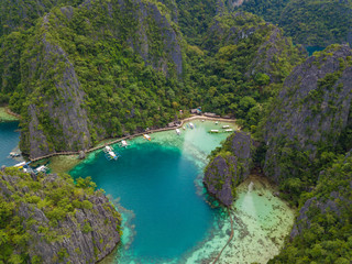 Obraz premium Aerial view to tropical lagoon with azure water and traditional sailing boats near Kayangan Lake, Coron island. Palawan, Philippines.