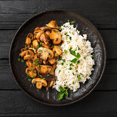 Risotto with  champignons mushrooms on black stone background .