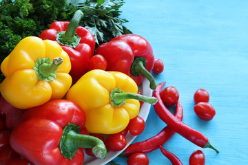 Fresh yellow and red peppers on a white wooden background