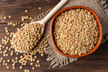 Green lentil on wooden background.
