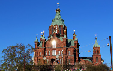 Fototapeta na wymiar Orthodox Uspenski Cathedral with red bricks and blue sky in spring in Helsinki