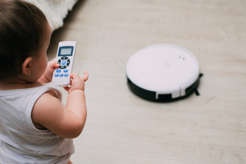 The child controls the robot with a remote vacuum cleaner