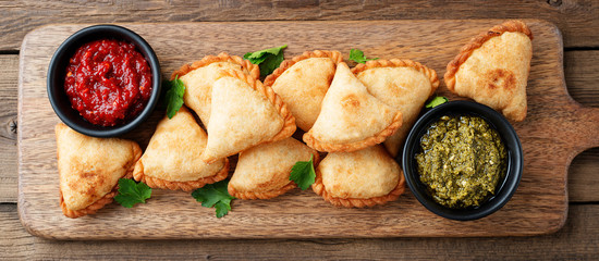 Vegetarian samosas filled with potato and green pea served with different sauces .Indian special...