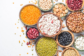 Legumes, lentils, chikpea and beans assortment on white.