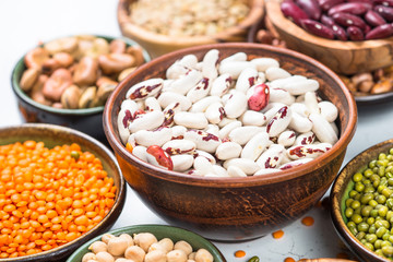 Legumes, lentils, chikpea and beans assortment on white.
