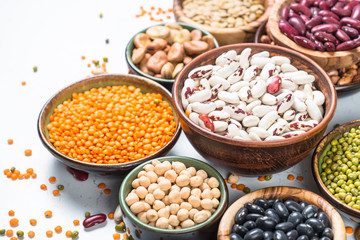 Legumes, lentils, chikpea and beans assortment on white.