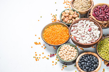 Legumes, lentils, chikpea and beans assortment on white.