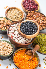 Legumes, lentils, chikpea and beans assortment on white.