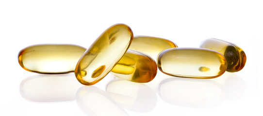 Close up of food supplement oil filled capsules suitable for: fish oil; omega 3; omega 6; omega 9; evening primrose; borage oil; flax seeds oil; vitamin A; vitamin D; vitamin D3; vitamin E - obrazy, fototapety, plakaty