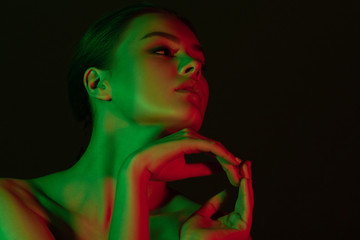 Young beautiful girl with green and red neon lighting