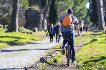 Naklejka premium ciclisti e turisti in bicicletta lungo l'Appia Antica a Roma