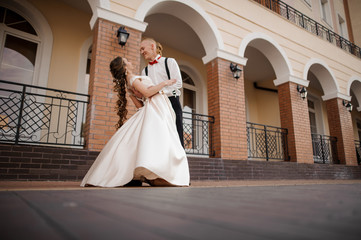 Happy young couple dancing near the beautiful building