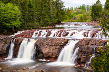 Obraz premium The waterfall in Lepreau, New Brunswick, Canada. Long exposure. Overcast day in summer.