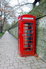 A traditional red telephone booth on a public telephone in Oxford - a symbol of the city. Vertical photo.